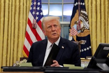 FILE PHOTO: U.S. President Donald Trump signs documents as he issues executive orders and pardons in the Oval Office at the White House on Inauguration Day in Washington, U.S., January 20, 2025. REUTERS/Carlos Barria/File Photo গাজা খালি করতে বাসিন্দাদের অন্য দেশে পাঠানোর পরিকল্পনা করছেন ট্রাম্প।